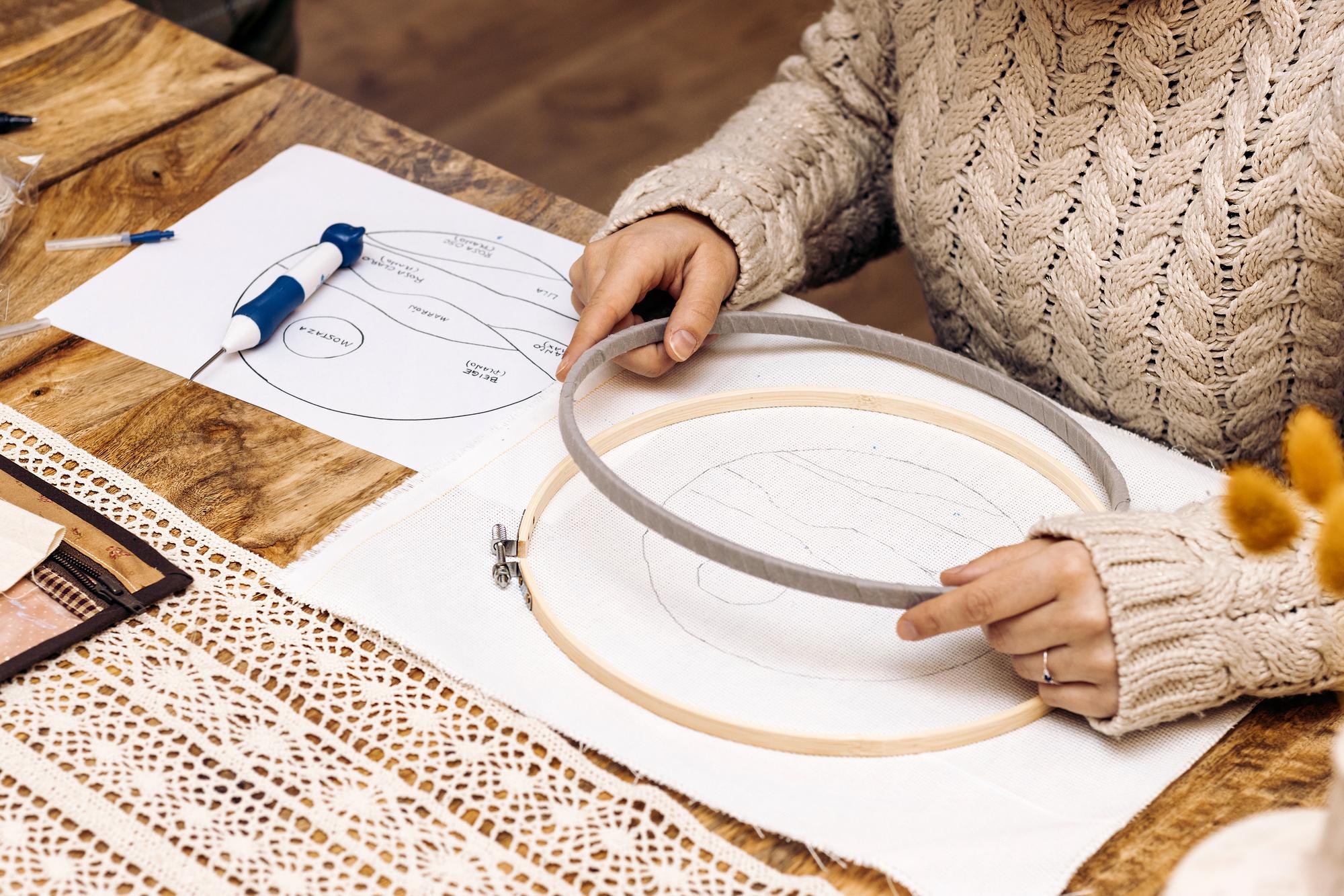 Studio workspace with embroidery hoops and CAD display